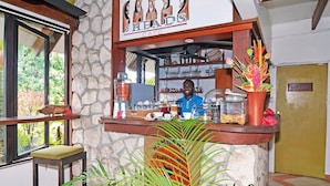 A cafe with a stone wall, a counter with a sign reading "HEADS CAFE", and a person behind the counter. - Coconut Palms Resort & Diamond Casino (Port Vila)