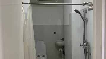 Un baño con inodoro, lavamanos y ducha.