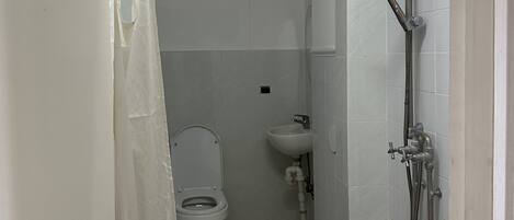 Un baño con inodoro, lavamanos y ducha.