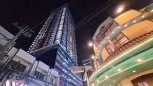 A multi-story building with illuminated signage, a restaurant with a neon sign, and a Family KTV & Resto Bar.