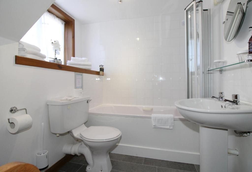 A bathroom with a toilet, bathtub, and sink.