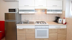 Una cocina compacta con microondas, refrigerador, estufa y horno.