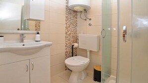 Une salle de bain équipée d’un lavabo, de toilettes et d’une douche à parois en verre.