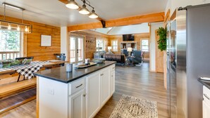 Une cuisine spacieuse aux murs en bois, dotée d’un grand îlot central et d’un réfrigérateur moderne.