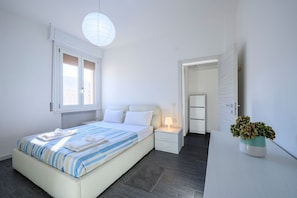 A bedroom with a bed, bedside table, lamp, and a potted plant. - GuestHost - Apartment located on the first floor of a building equipped with a lift (not suitable for disabled people).In 88 m2 of space it accommodates 4 peopleThe property is located in a strategic point near the train station and the historic center o (Parma)