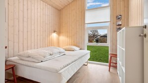 Ein Schlafzimmer mit einem Bett, einem Fenster und einer Tür.