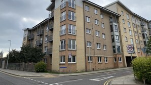 A multi-story residential building with a 20 mph speed limit sign, a street name sign, and a gated entrance. - Orange Apartments Bothwell Road (Aberdeen)