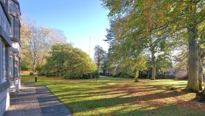 A pathway leading to a grassy area with trees and a building on the left. - Orange Apartments Beechgrove (Aberdeen)