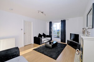 A modern living room with a sofa, coffee table, and TV.