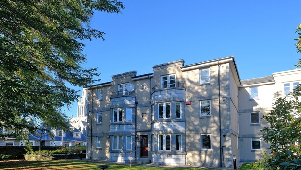 A multi-story residential building with a symmetrical facade, large windows, and a well-maintained lawn. - Orange Apartments Beechgrove (Aberdeen)