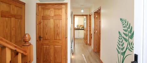 A hallway with wooden doors and a sign that reads 'Be our guest.'