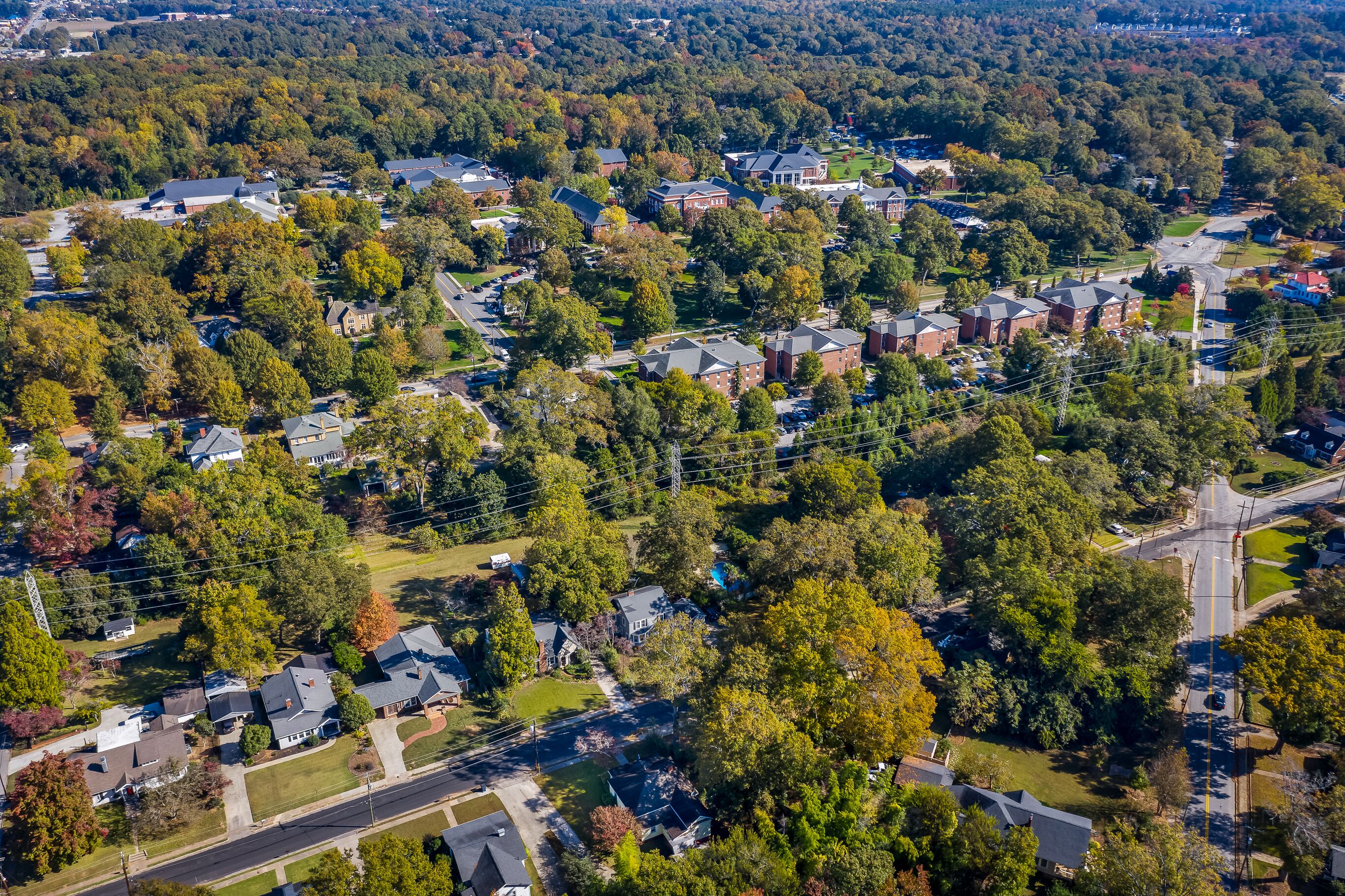 Vista aérea de un barrio residencial con casas, calles y árboles.