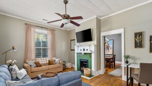 Una sala de estar con sofá, televisión, chimenea y comedor.
