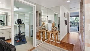 A home interior with a mirrored closet, exercise equipment, and a wooden staircase leading to a balcony. - "Modern" Zephyr, 3 mins to beach, 7 mins to Heavenly, Casinos (Zephyr Cove)