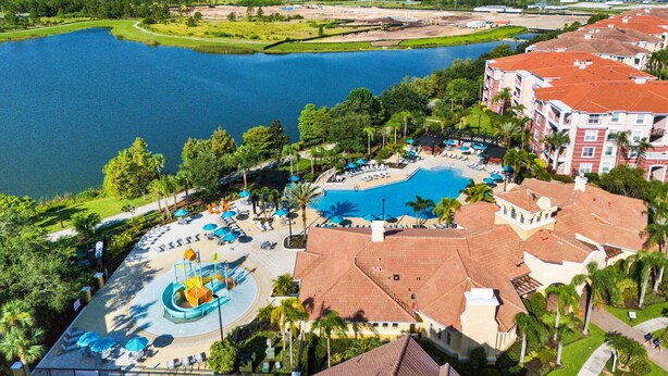 A resort with a large swimming pool, a water park, and a view of a lake.