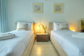 A hotel room with two beds, a bedside table with a lamp, and two framed pictures on the wall. - Large & modern 3bedroom in prime location WPAC1-1 (St Julian's)