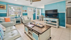 Un salon moderne avec un canapé, une table basse et un téléviseur.