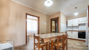 Cocina compacta con una mesa de comedor, sillas y electrodomésticos esenciales.