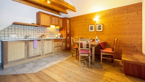 Un intérieur en bois comprenant une cuisine, un coin repas et un plafond en bois.