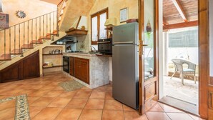 Une cuisine équipée d’un réfrigérateur, d’une cuisinière et de meubles de rangement en bois.