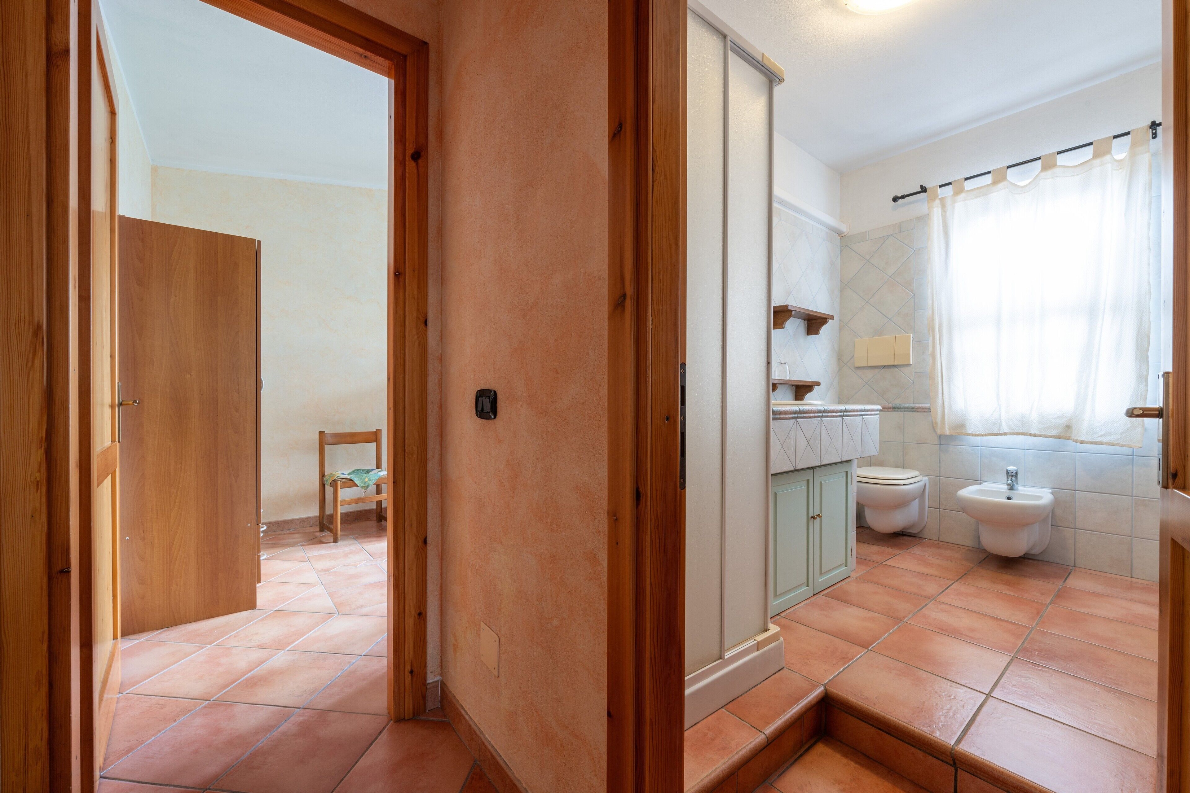 Une salle de bain avec douche, toilettes et lavabo.