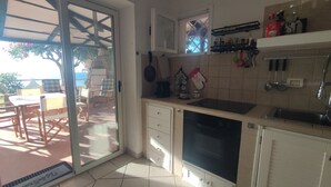 A kitchen with a sliding glass door leading to an outdoor seating area. - Villa 'Costa Dei Monaci Villas - Tropea' with Sea View, Wi-Fi and Air Conditioning (Costa dei Monaci)
