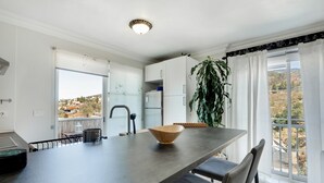 Een moderne keuken met een grote tafel, een schaal en een potplant.