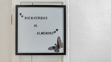 Letrero de bienvenida enmarco con la inscripción 'BIENVENIDOS AL ALMENDRO' y detalles decorativos.