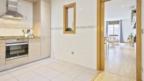 Una cocina moderna con electrodomésticos de acero inoxidable, una puerta de madera y un comedor con vistas.