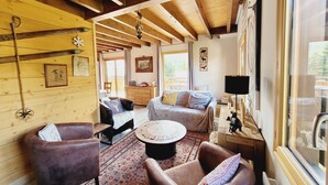A cozy cabin interior with wooden walls, a bed, a sofa, and a dining area. - Warm chalet for 6 people, Saint-Chaffrey (Saint-Chaffrey)