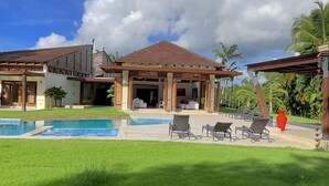 Ein Resort mit Schwimmbad, Liegestühlen und einer überdachten Terrasse.