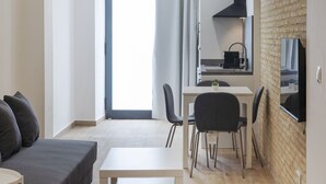 Un salon moderne comprenant un canapé, une table basse et un coin repas avec des chaises et une table.