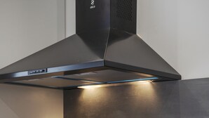 Une cuisine moderne équipée d’une cuisinière intégrée, d’une hotte aspirante et d’une machine à café.