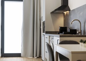 A modern kitchen with a built-in oven, a coffee machine, and a stainless steel sink. - VLC HOST - Fray Pedro E (Valencia)
