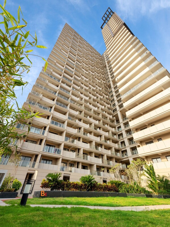 A high-rise building with multiple balconies and a sign that reads "Be".