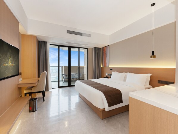 Una habitación de hotel moderna con una cama grande, un escritorio, un televisor y un balcón con vistas.