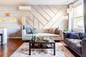 Een moderne woonkamer met een bank, een salontafel en een raam.
