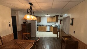 A compact kitchen with wooden cabinets, a microwave, and a refrigerator. - Spacious 2 Bedroom Apartment downtown Winifred,8 miles from the Missouri Breaks! (Winifred)