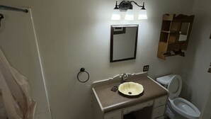 A bathroom with a sink, mirror, toilet, and a towel rack. - Spacious 2 Bedroom Apartment downtown Winifred,8 miles from the Missouri Breaks! (Winifred)