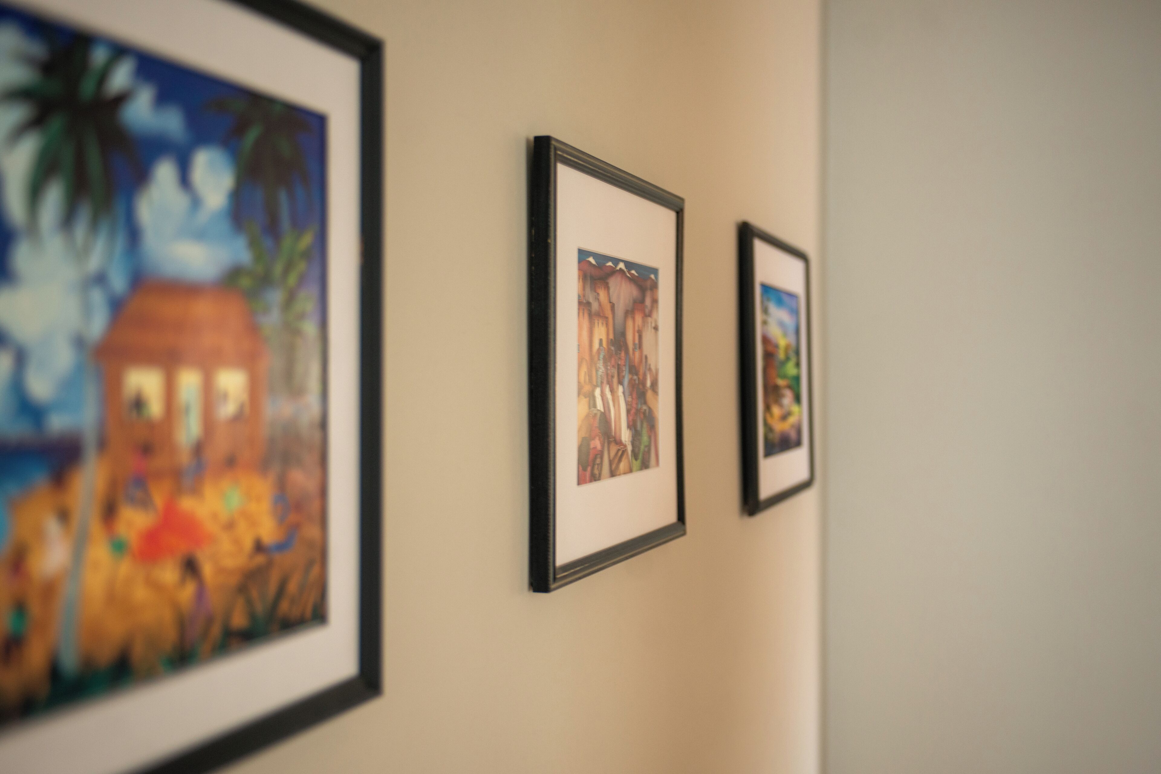 Trois œuvres d’art encadrées sont accrochées au mur.