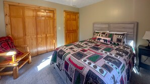 Un dormitorio con una cama grande, armario de madera y ventilador de techo.
