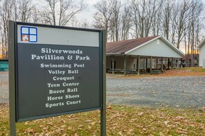 A sign listing amenities at Silverwoods Pavilion & Park, including a swimming pool, volleyball, croquet, teen center, bocce ball, horse shoes, and sports court.