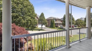 A covered porch with a view of a suburban neighborhood, including houses and trees. - The cozy corner house in the Richmond Hill  (Richmond Hill)