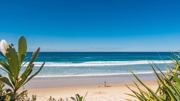 A beach with clear blue water and a sandy shore. - Beachcombers Cottage - beachfront pet retreat (Suffolk Park)