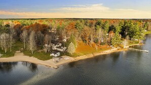 A lakeside property with a dock, a small house, and a boat. - ~Fireworks On The 3rd~Sunrise Vista~Lakefront~Dock~Kayaks~Hot Tub~Games~NEW AC~ (Gaylord)