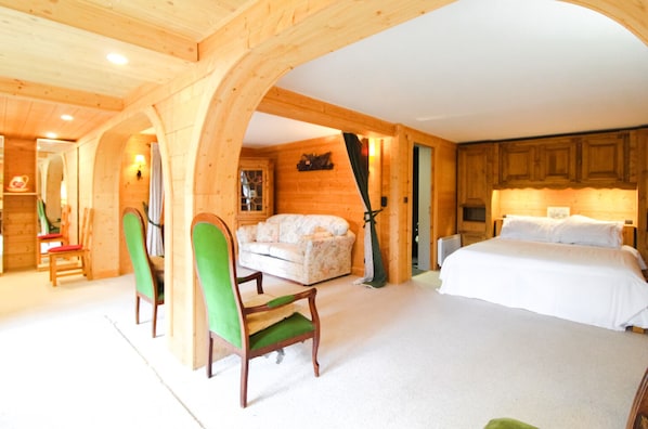 Un interior de madera con una cama, un sofá y sillas.