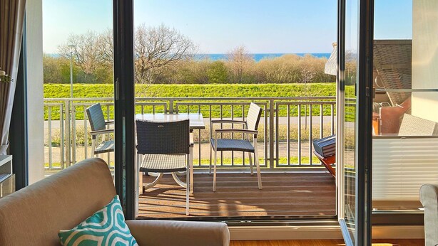 A balcony with a view of the sea, a table, and chairs. - Apartment 'Villa Deichgraf 07 Ostseeblick' with Sea View, Balcony and Wi-Fi (Börgerende-Rethwisch)