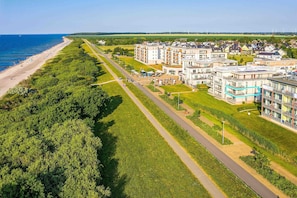 Vista aérea de una zona residencial costera con playa, carretera y modernos edificios de apartamentos.