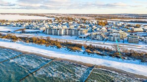 A residential area with houses, a large building, and a river. - Apartment 'Villa Deichgraf 12 Meerblick' with Sea View, Balcony and Wi-Fi (Börgerende-Rethwisch)