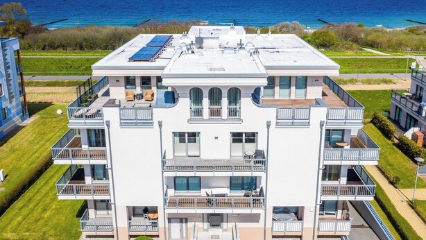 A multi-story building with balconies, solar panels, and a view of the sea. - Apartment 'Villa Deichgraf 12 Meerblick' with Sea View, Balcony and Wi-Fi (Börgerende-Rethwisch)